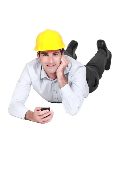 Architect laying down with mobile telephone — Stock Photo, Image