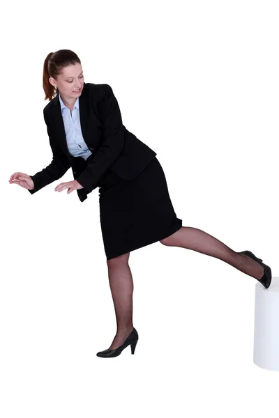 Businesswoman kicking a stool — Stock Photo, Image