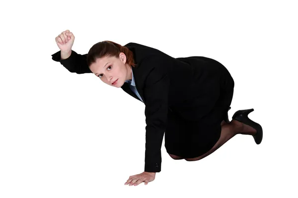 Businesswoman kneeling on the floor and holding up her fist — Stock Photo, Image