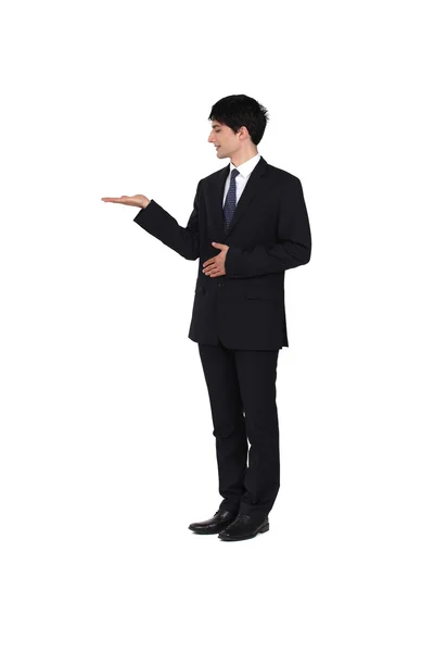 Muž na sobě oblek a prezentaci jeho pravá ruka — Stock fotografie