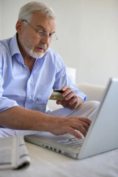 Senior man die een aankoop on-line — Stockfoto