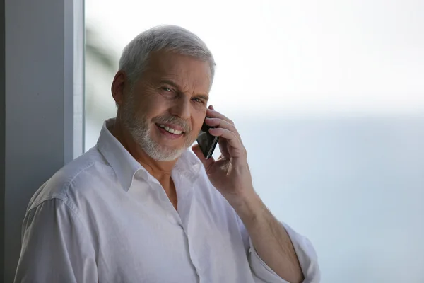 Oudere man met een telefoon — Stockfoto
