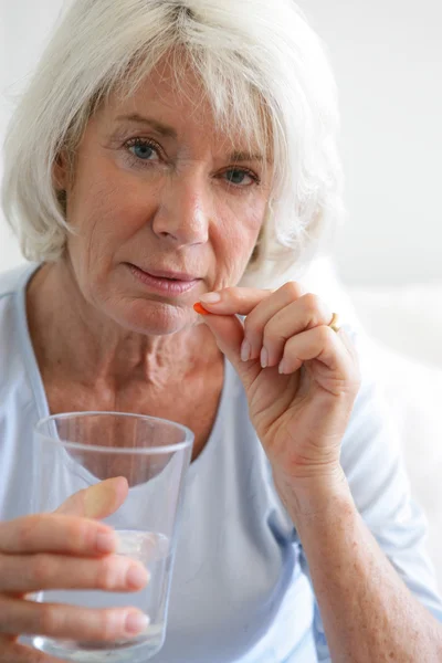 Senior woman taking her medication — Stock Photo, Image