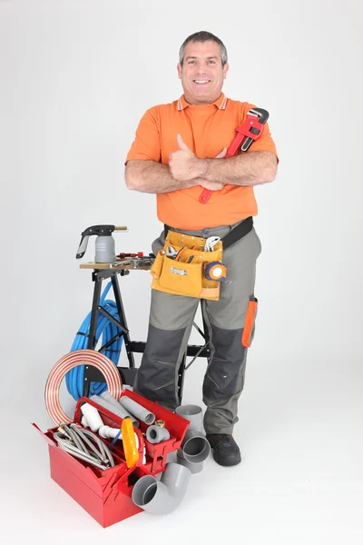 Smiling man at workbench with tools — Stock Photo, Image