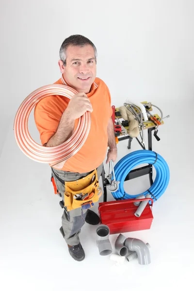 Plumber holding copper piping with various other materials Royalty Free Stock Images