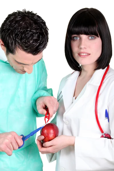 Surgeon operating on apple — Stock Photo, Image