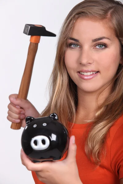 Jonge vrouw smashing haar piggy bank — Stockfoto