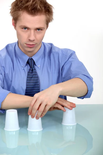 Hombre realizando truco con tres tazas —  Fotos de Stock