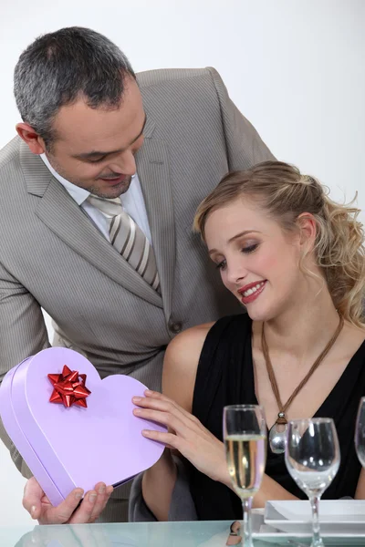 Blondine erhält Geschenk von Freund bei romantischem Dinner — Stockfoto
