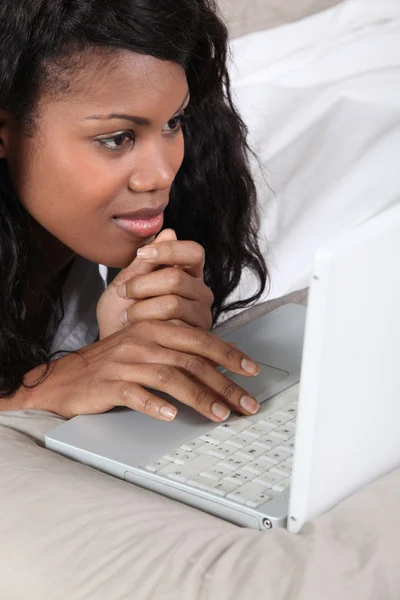 Fekete lady használ laptop az ágyban — Stock Fotó