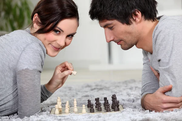 Bonito jovem casal jogando xadrez juntos — Fotografia de Stock