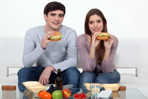 Genç bir çift hamburger yemek — Stok fotoğraf