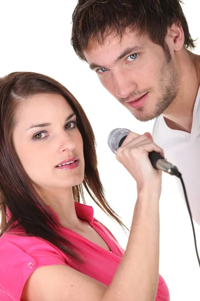 Young couple singing into a microphone Stock Image