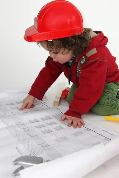 Pequeño niño constructor leyendo periódico — Foto de Stock