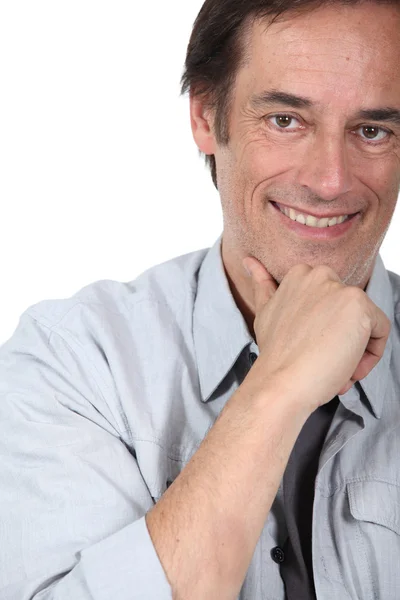 Hombre sonriendo sosteniendo la barbilla . — Foto de Stock