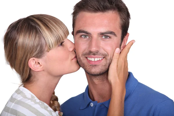 Молода жінка цілує чоловіка — стокове фото
