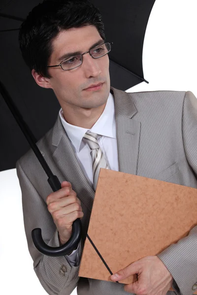 Young businessman holding umbrella — Stock Photo, Image