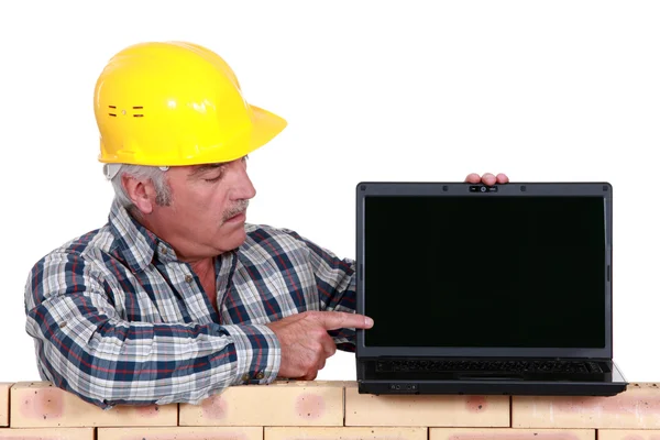 Constructor que apunta a la pantalla del ordenador portátil Imagen de stock