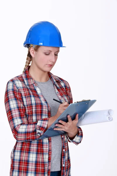 Trabajadora de la construcción escribiendo en portapapeles — Foto de Stock