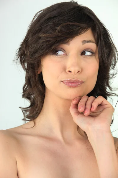 Kop en schouders van een naakte vrouw haar kin op haar hand rusten — Stockfoto