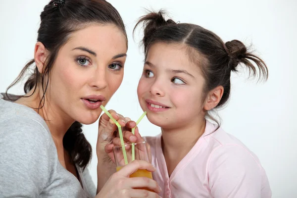 Mother and daughter sharing a drink Royalty Free Stock Images
