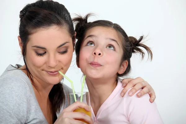 Mother and daughter sharing a drink Stock Photo