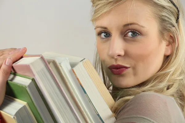 Žena nesoucí hromádku knih — Stock fotografie