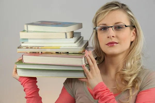 Loiro atraente carregando pilha de livros — Fotografia de Stock