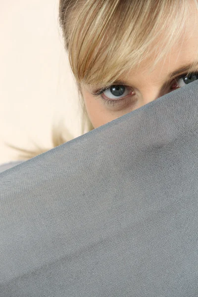 Joven rubia observando detrás de la sábana — Foto de Stock