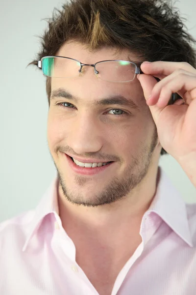 Porträtt av en man som lyfter hans glasögon — Stockfoto