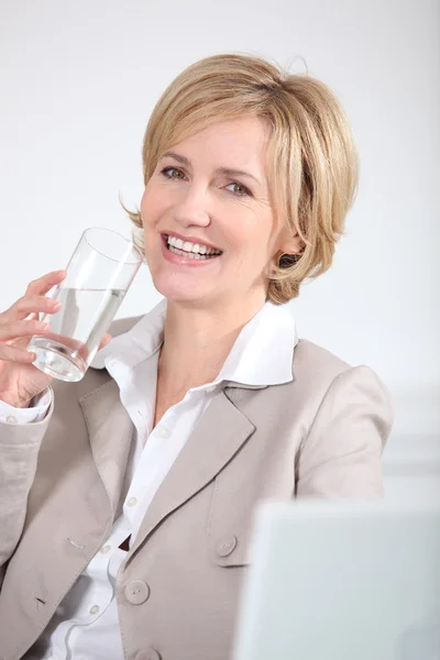 Porträtt av en affärskvinna med glas vatten — Stockfoto