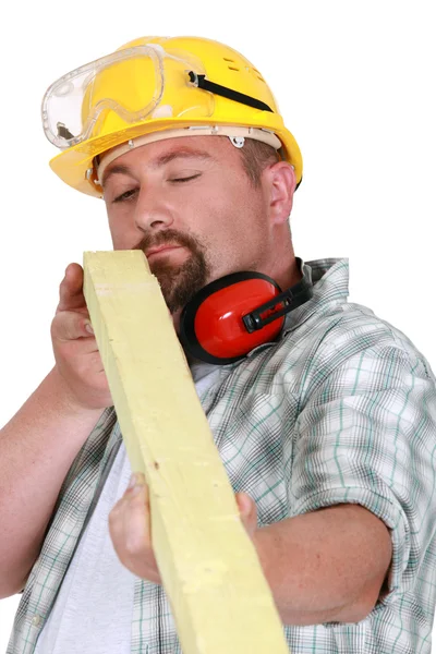 Worker eyeing a piece of wood — Stock Photo, Image