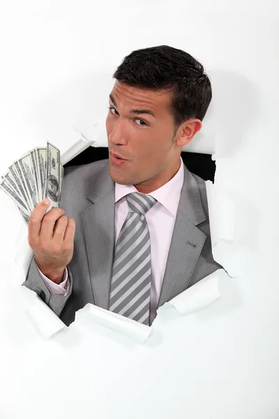 Man with banknotes of paper coming out of hole — Stock Photo, Image