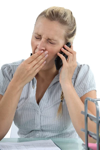 Vrouw praten over de telefoon en geeuwen — Stockfoto