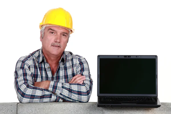 Ремесленник покоится на бетонной стене с компьютером Стоковое Изображение