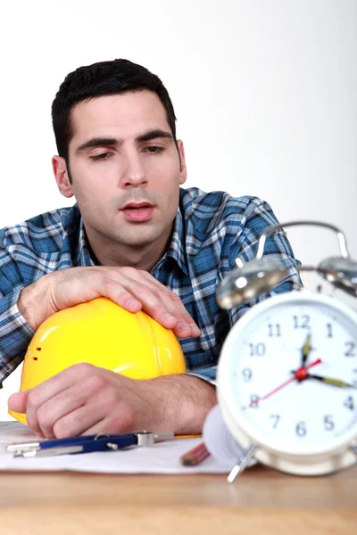 Builder being woken up by alarm clock — Stock Photo, Image