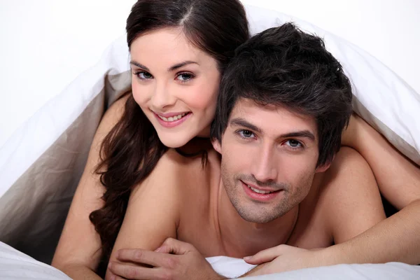 Jeune couple au lit ensemble — Photo
