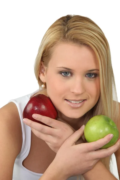 Young blonde woman with a red and a green apple — Stock Photo, Image