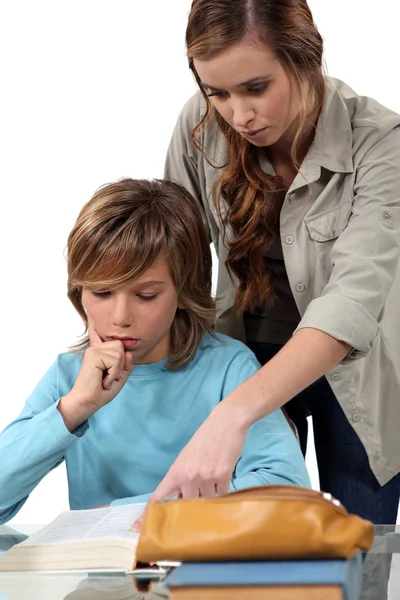 Adolescent garçon faire ses devoirs sous jeune professeur — Photo