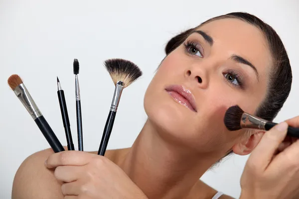 Žena držící různé make-up štětce — Stock fotografie