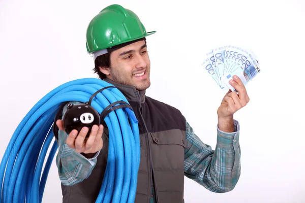 Plumber holding his wages — Stock Photo, Image