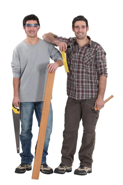 Two carpenters stood with plank of wood — Stok fotoğraf