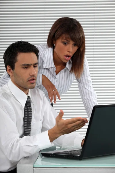 Dois empresários chocados pela tela do laptop — Fotografia de Stock