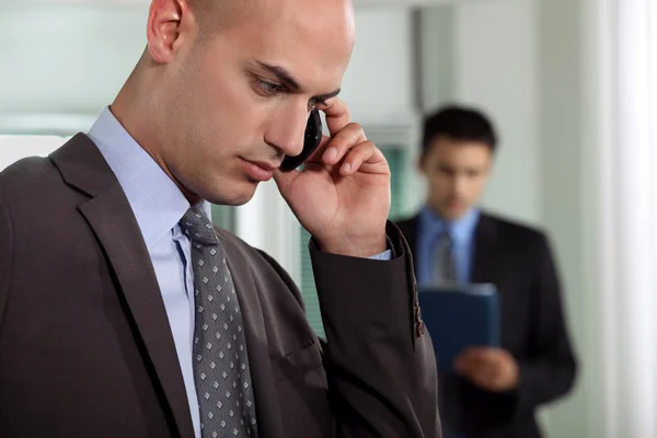 Businessmen negotiating over the phone — Stock Photo, Image