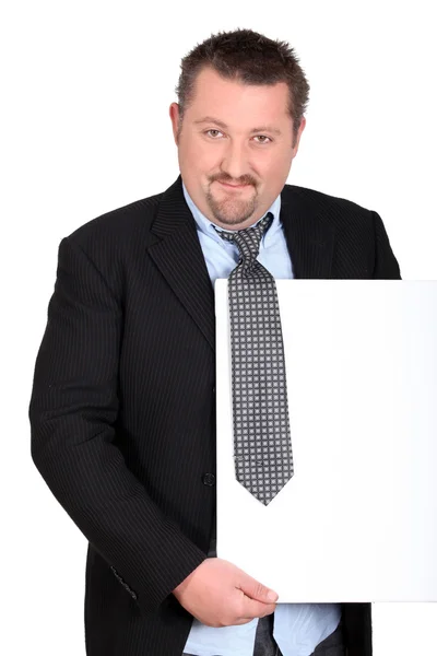 Hombre con traje y corbata sosteniendo una tabla en blanco para su mensaje —  Fotos de Stock