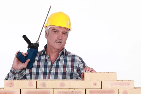 Construtor com uma broca de alvenaria — Fotografia de Stock