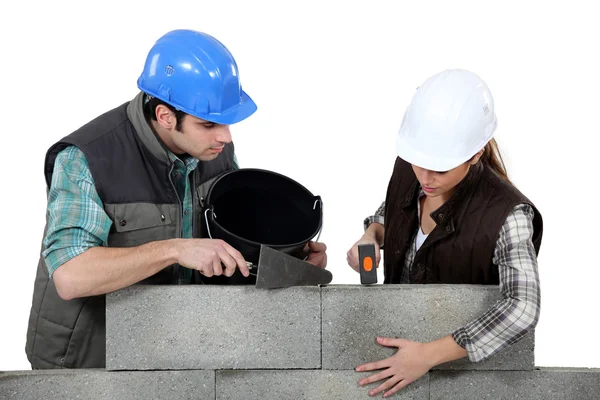 Craftsman and craftswoman applying cement — Stock Photo, Image