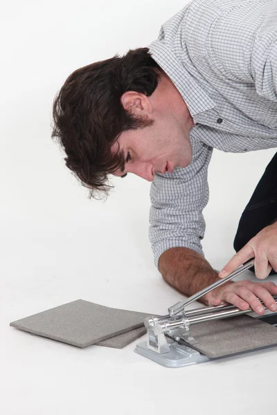 Hombre usando un cortador de azulejos — Foto de Stock