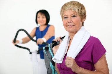 Two middle-aged women at the gym clipart