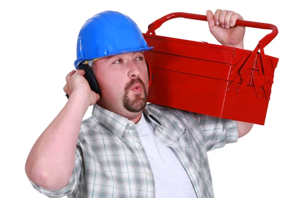 Artesano usando auriculares y llevando una caja de herramientas —  Fotos de Stock